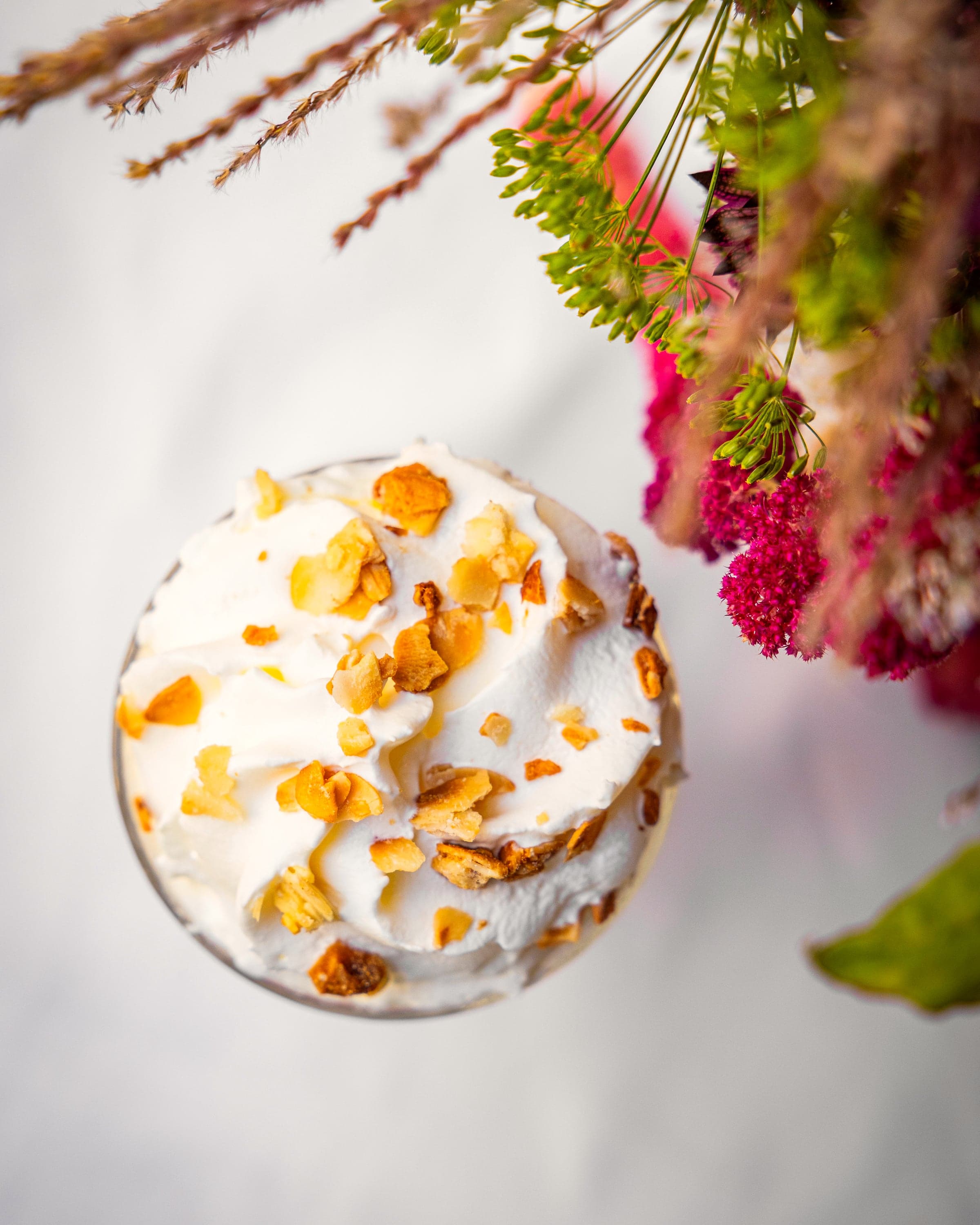 Dessert glacé vu de dessus, dressé près d’un bouquet