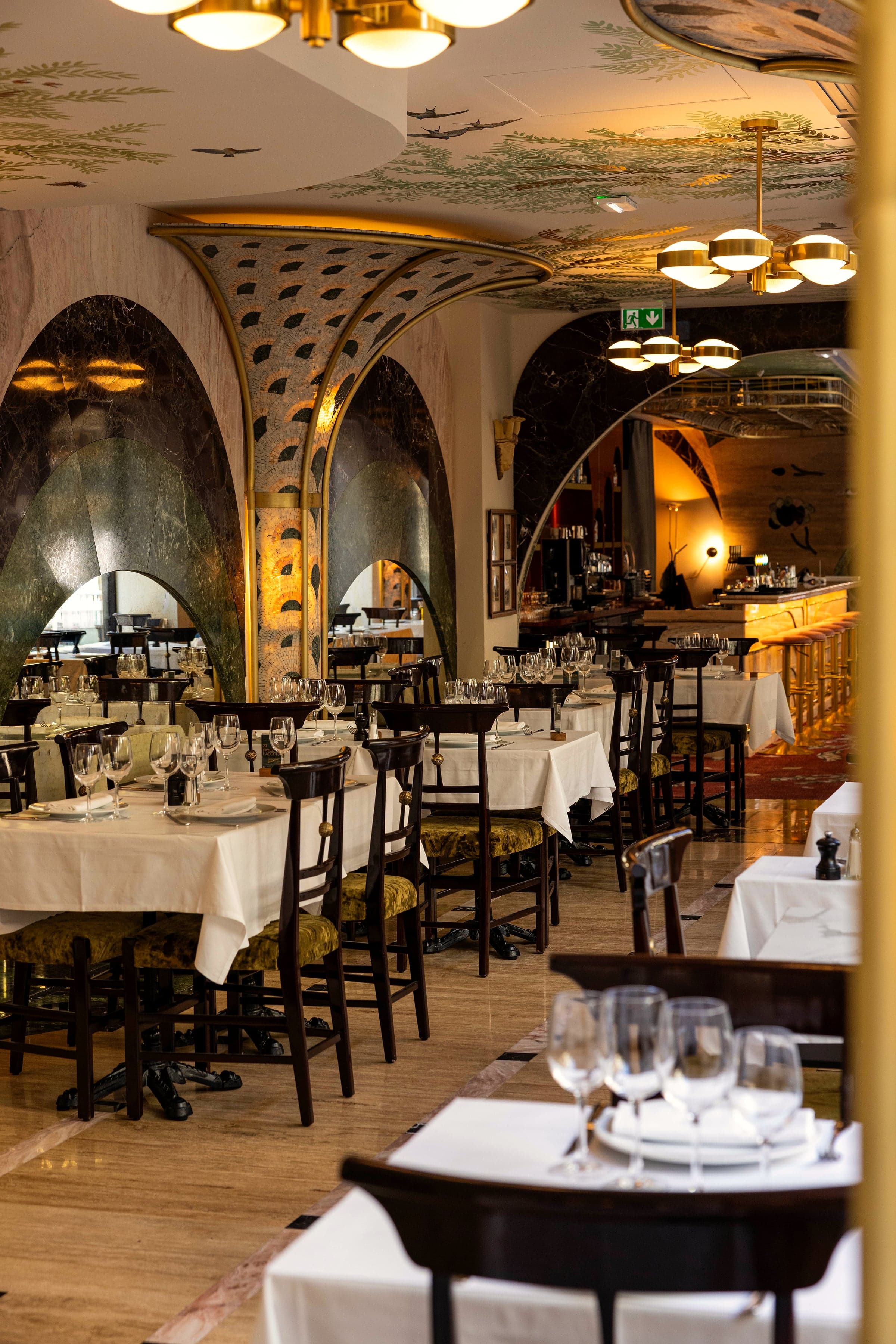 Salle voûtée de la brasserie, mosaïques au plafond et tables nappées de blanc